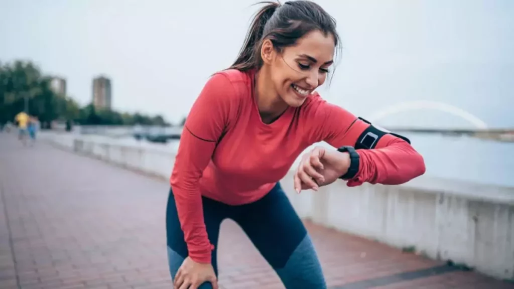 Mulher chegando relógio fitness enquanto corre