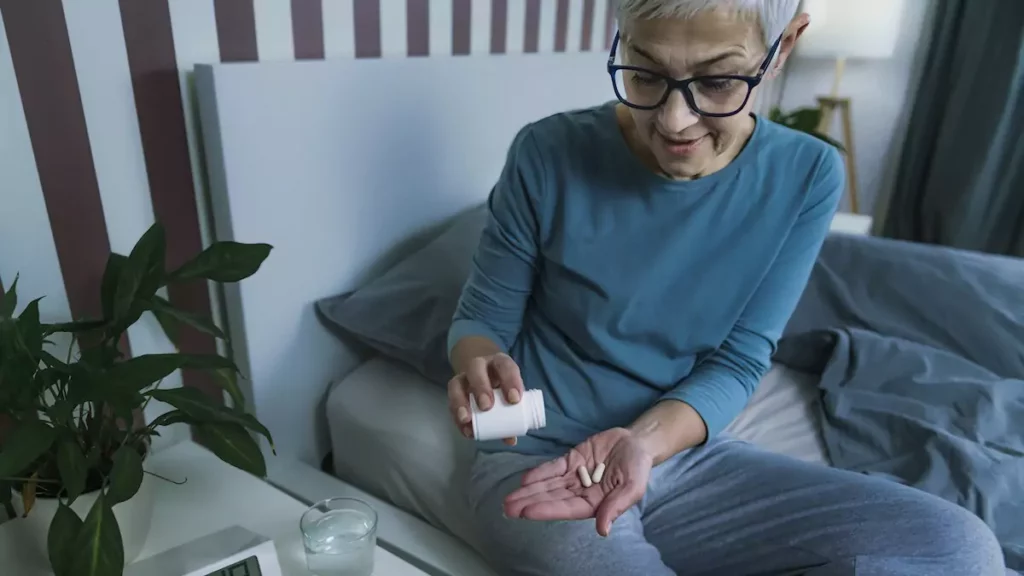 Idosa fazendo uso de melatonina ao pé da cama