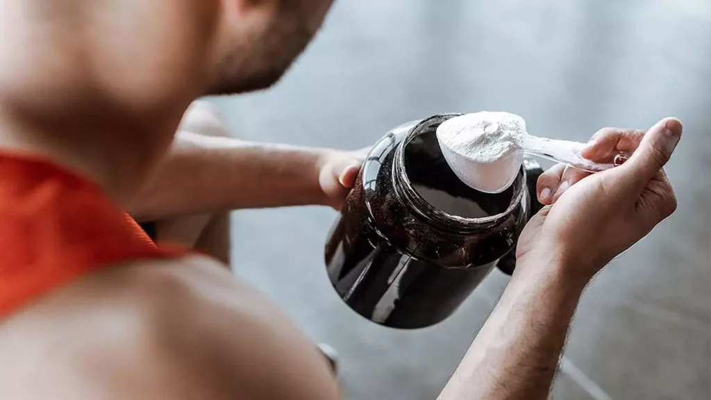 Homem retirando dose de pré-treino de pote