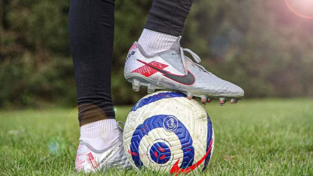 Homem dominando bola com chuteira de campo